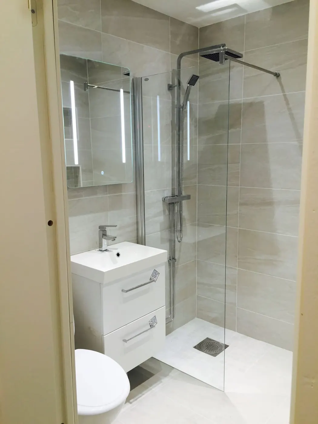 Douche vitrée en carrelage clair