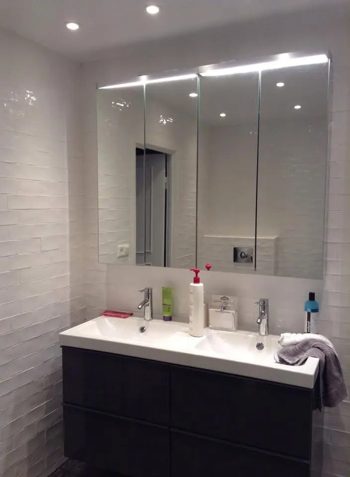 Salle de bain avec double vasque, murs carrelés