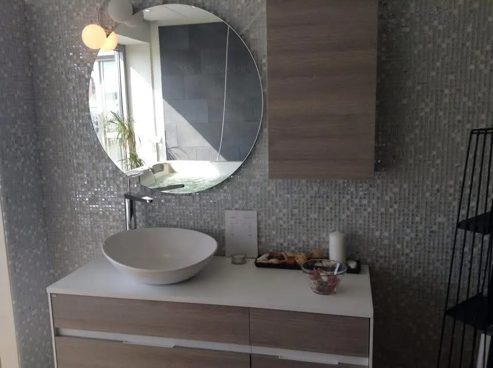 Salle de bain en mosaïque avec miroir rond